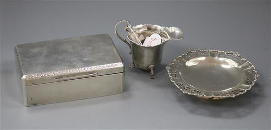 A silver helmet shaped cream jug, a silver mounted cigarette box and a silver bon-bon dish.